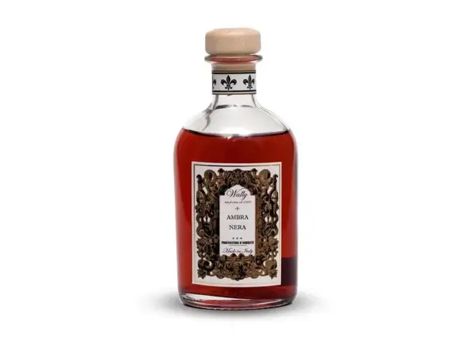Una bottiglia in vetro di Ambra Nera Profumatore d'ambiente, riempita di liquido Rosso trasparente, fornita di etichetta decorativa e tappo in legno.