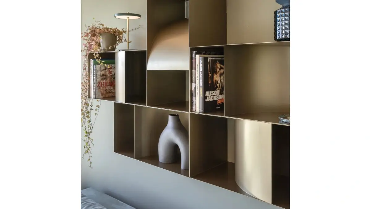 Dettagli di Judd Pensile contenitore sospeso in finitura dark bronze con libri e altri oggetti.