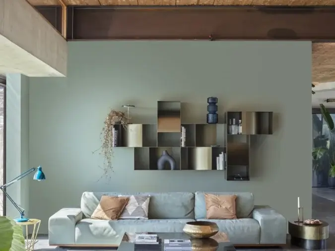 Judd Pensile contenitori a parete in finitura Dark Bronze in una living room con un divano con dei cuscini, due tavolini ed una lampada.