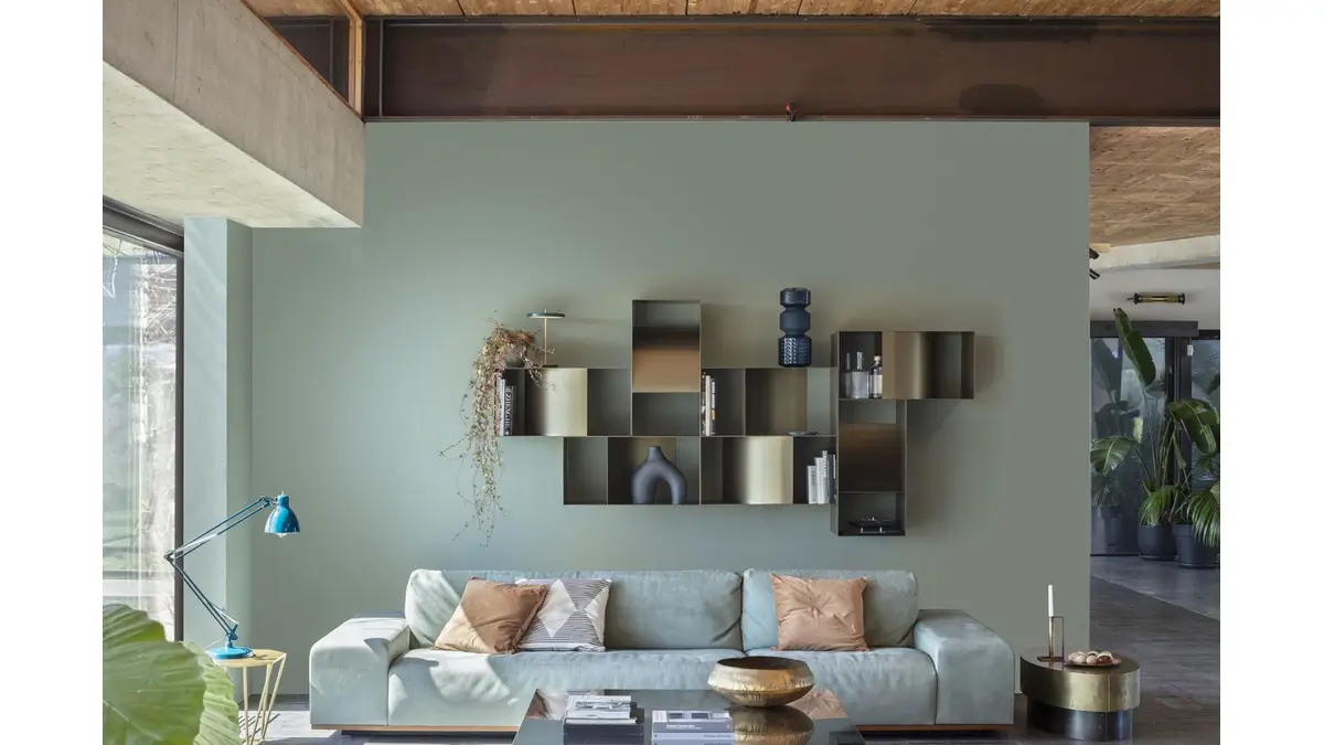Judd Pensile contenitori a parete in finitura Dark Bronze in una living room con un divano con dei cuscini, due tavolini ed una lampada.