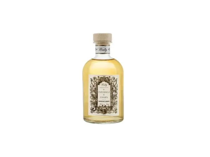 Una bottiglia in vetro di Patchouli E Canapa Profumatore d'ambiente, riempita di liquido giallo ambra, fornita di etichetta decorativa e tappo in legno.