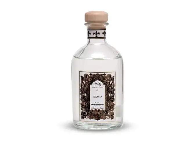 Una bottiglia in vetro di Peonia Profumatore d'ambiente, riempita di liquido bianco trasparente, fornita di etichetta decorativa e tappo in legno.