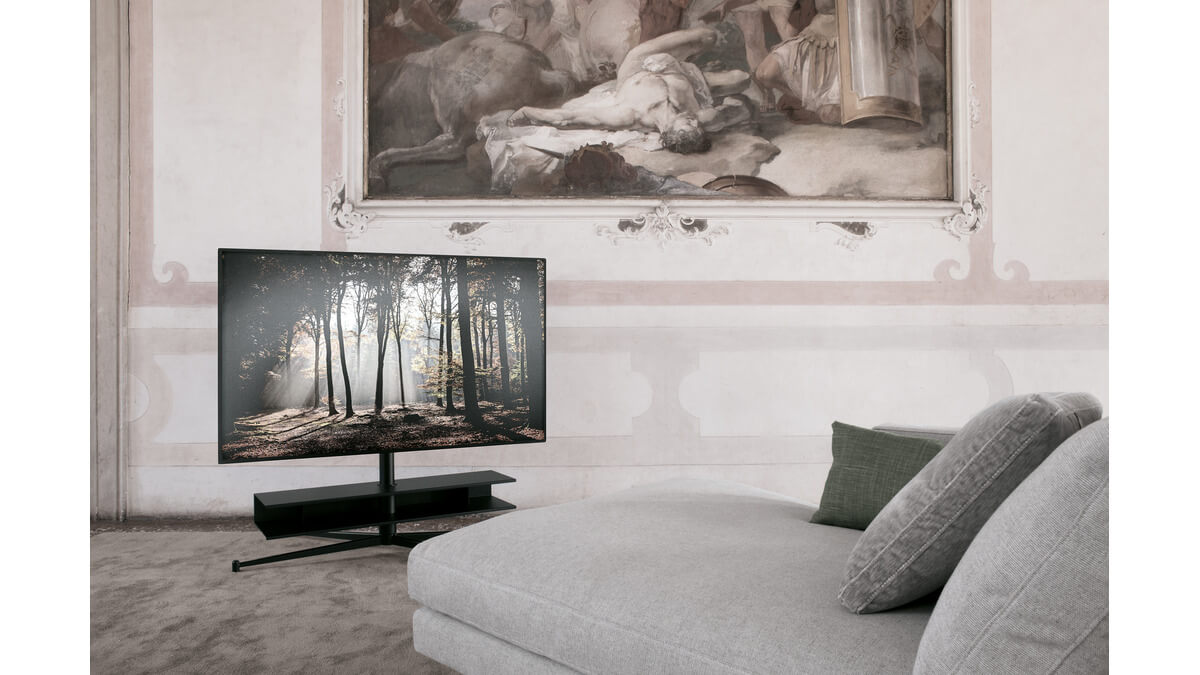 PortaTv Titano in finitura nera con TV accesa in una stanza con divano ed un quadro