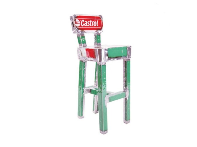 Adorabile sgabello realizzato con gambe in metallo verde e uno schienale fatto da una lamiera di recupero da bidone della Castrol.
