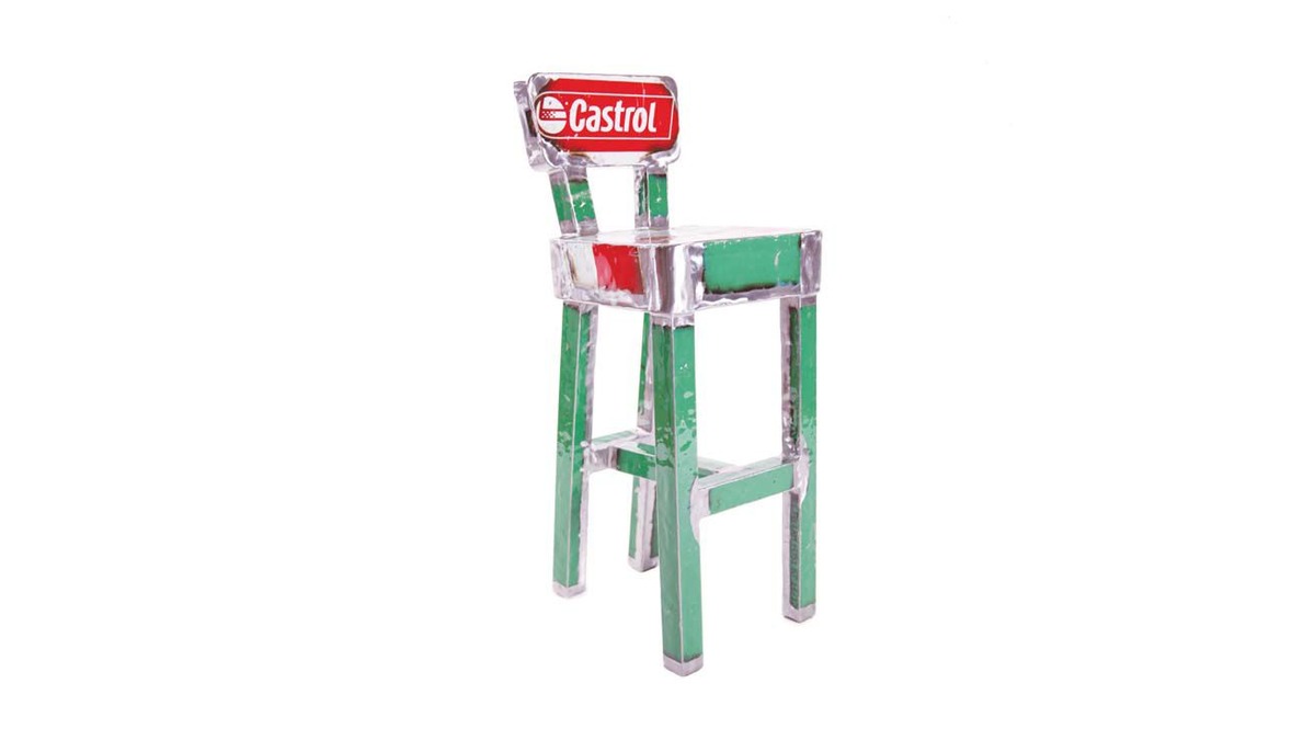 Adorabile sgabello realizzato con gambe in metallo verde e uno schienale fatto da una lamiera di recupero da bidone della Castrol.