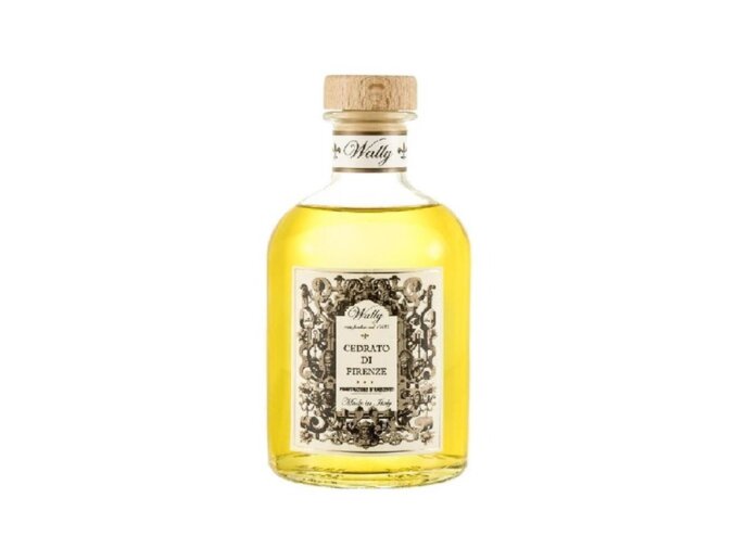 Una bottiglia in vetro di Cedrato di Firenze Profumatore d'ambiente, riempita di liquido giallo, fornita di etichetta decorativa e tappo in legno.