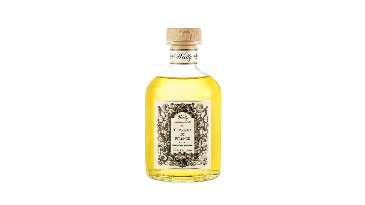 Una bottiglia in vetro di Cedrato di Firenze Profumatore d'ambiente, riempita di liquido giallo, fornita di etichetta decorativa e tappo in legno.
