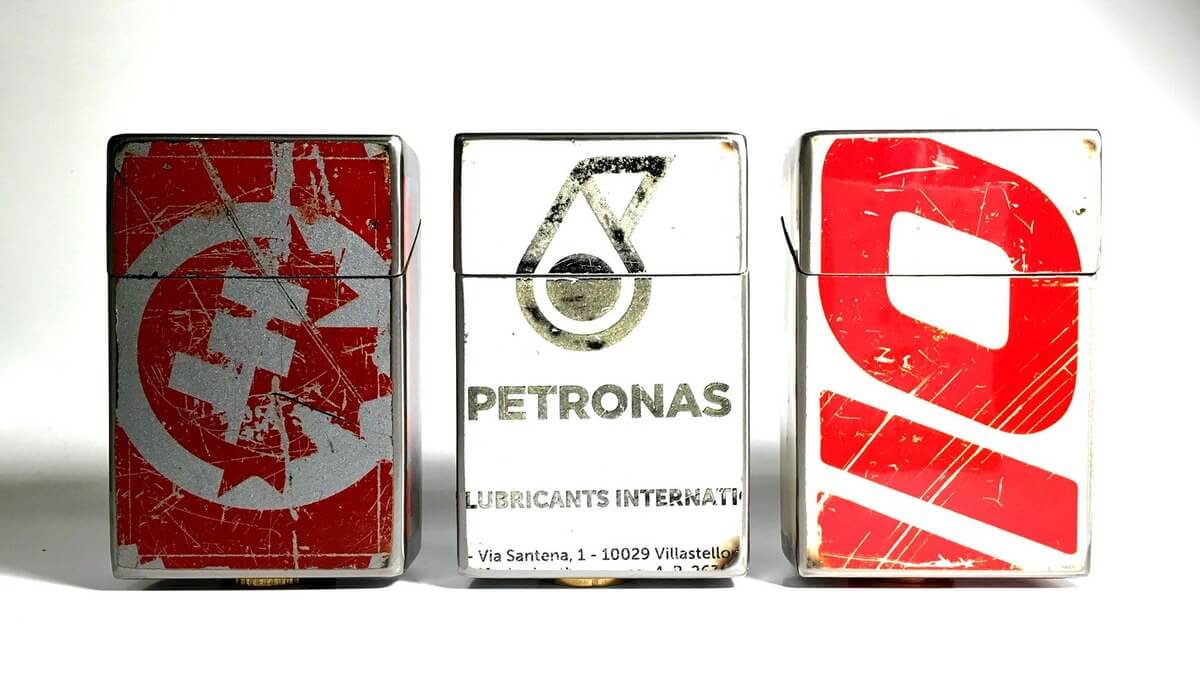 Tre Ciggy Box contenitore per pacchetto di sigarette in lamiera di bidone in vari colori su uno sfondo bianco.