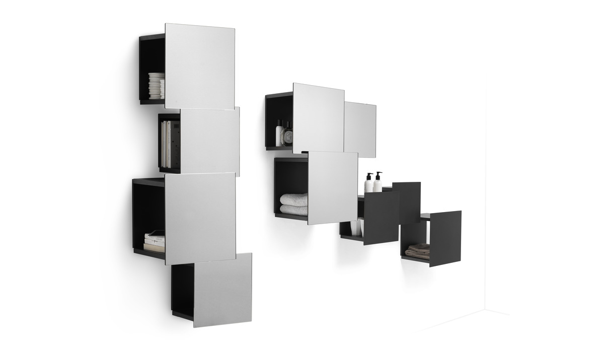 Dettagli della composizione di scaffali modulari DPI libreria a parete in finitura metallo antracite con libri ed oggetti poggiati all'interno dei vari moduli.