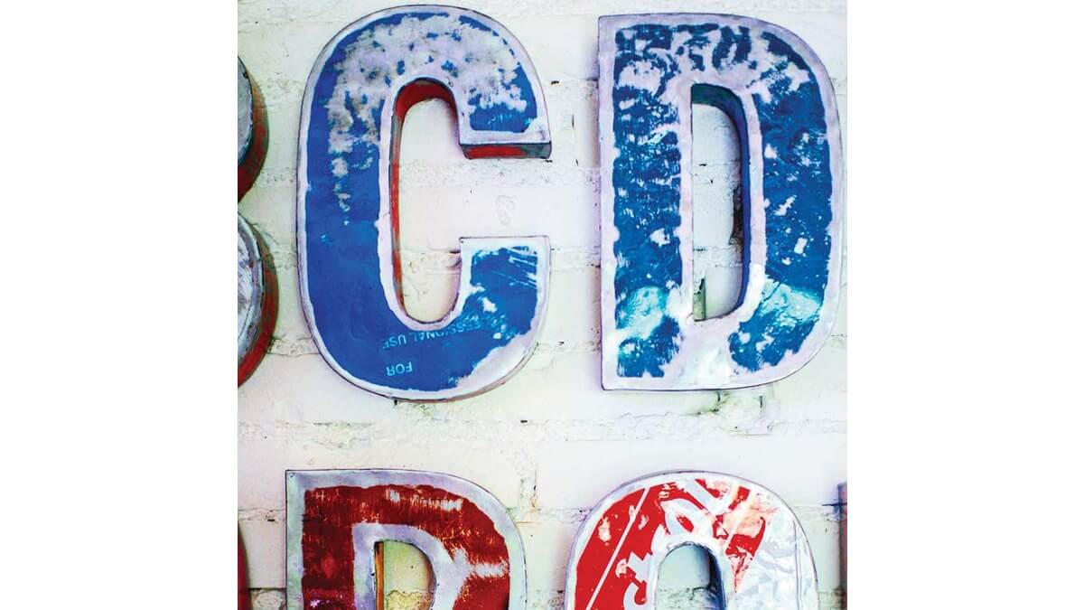 Dettagli di Font lettere in lamiera di bidone rosso e blu con scritta Castrol. Si vedono le lettere C e D.