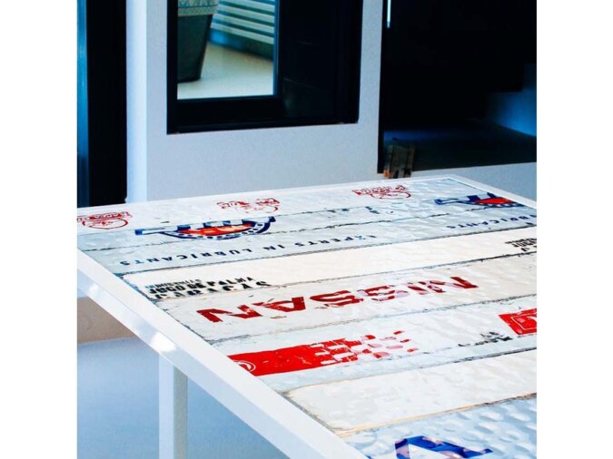 Leggero Tavolo fisso in lamiera bianca di bidone con scritte rosse posto in dining room con uno specchio sullo sfondo.