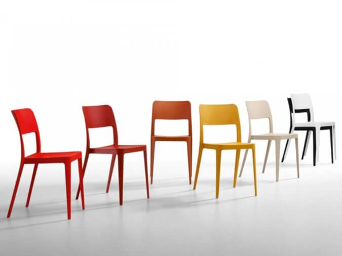 Sette sedie Nenè di colore rosso, arncione, giallo, bianco perla, bianco e nero.