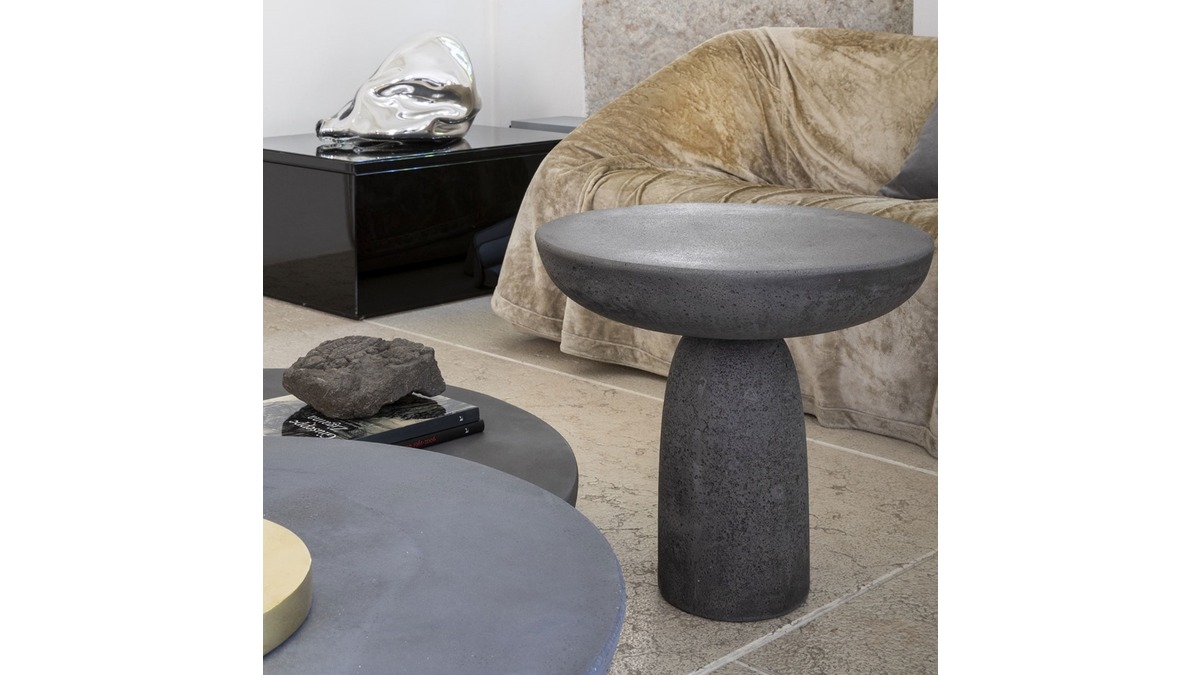 Living Room con vari Olo Coffee Tables in cemento color antracite, un morbido divano in velluto beige e una scultura artistica su un tavolino nero.