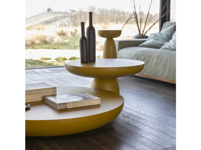 Living Room moderno caratterizzato da vari Olo Coffee Tables con bottiglie e libri, sullo sfondo un comodo divano e una serena vista all'aperto.