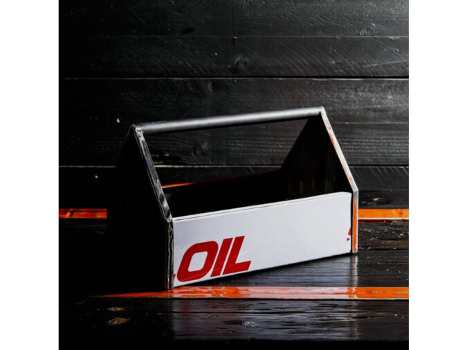 Cassetta degli attrezzi Petrolhead Toolbox in lamiera di bidone OIL, appoggiata su un piano di legno nero e arancione.