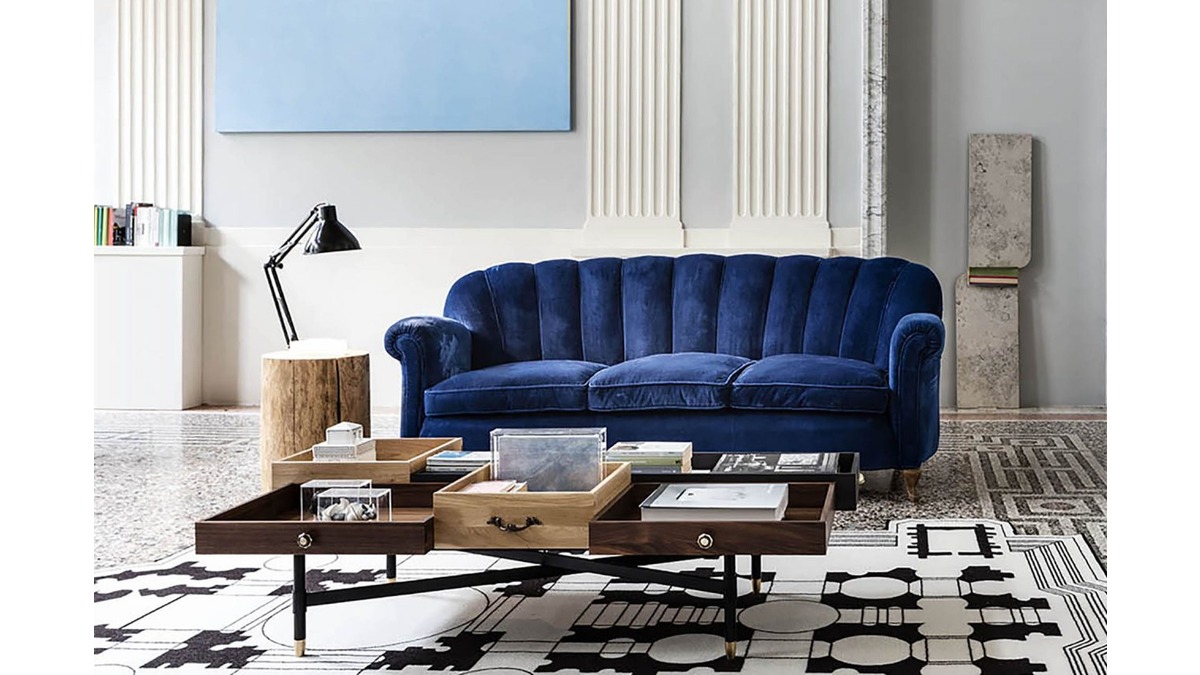 Piantama Lamp nera con tavolino in legno in una stanza con divano blu, coffee tables ed un tappeto bianco e nero.