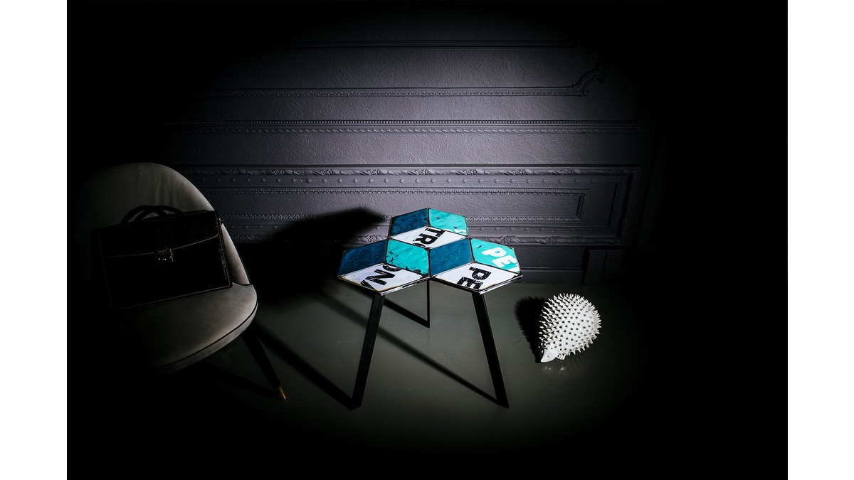 Coffee Table Prisma in lamiera di bidone blu in living room con una poltroncina grigia ed un animaletto in porcellana.