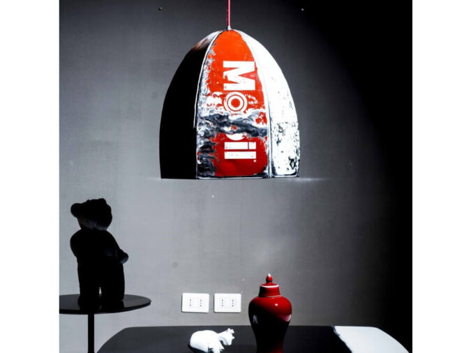 Pendant Lamp Rugby in lamiera di bidone bianca e rosso con scritta Mobil in living room con un tavolo nero, sul quale sono poggiati un vaso rosso e altri oggetti.