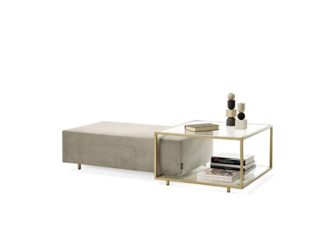 Zoom Coffee table in vetro con struttura in bronzo patinato, ornato con bottiglie decorative e libri, abbinato a un pouf in velluto.